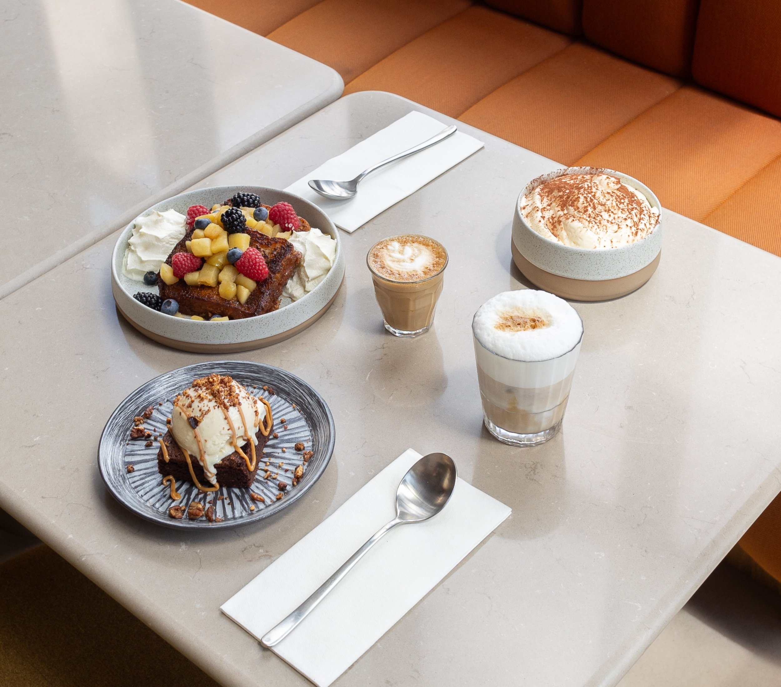 Overall photo of a table with coffee and desserts to share